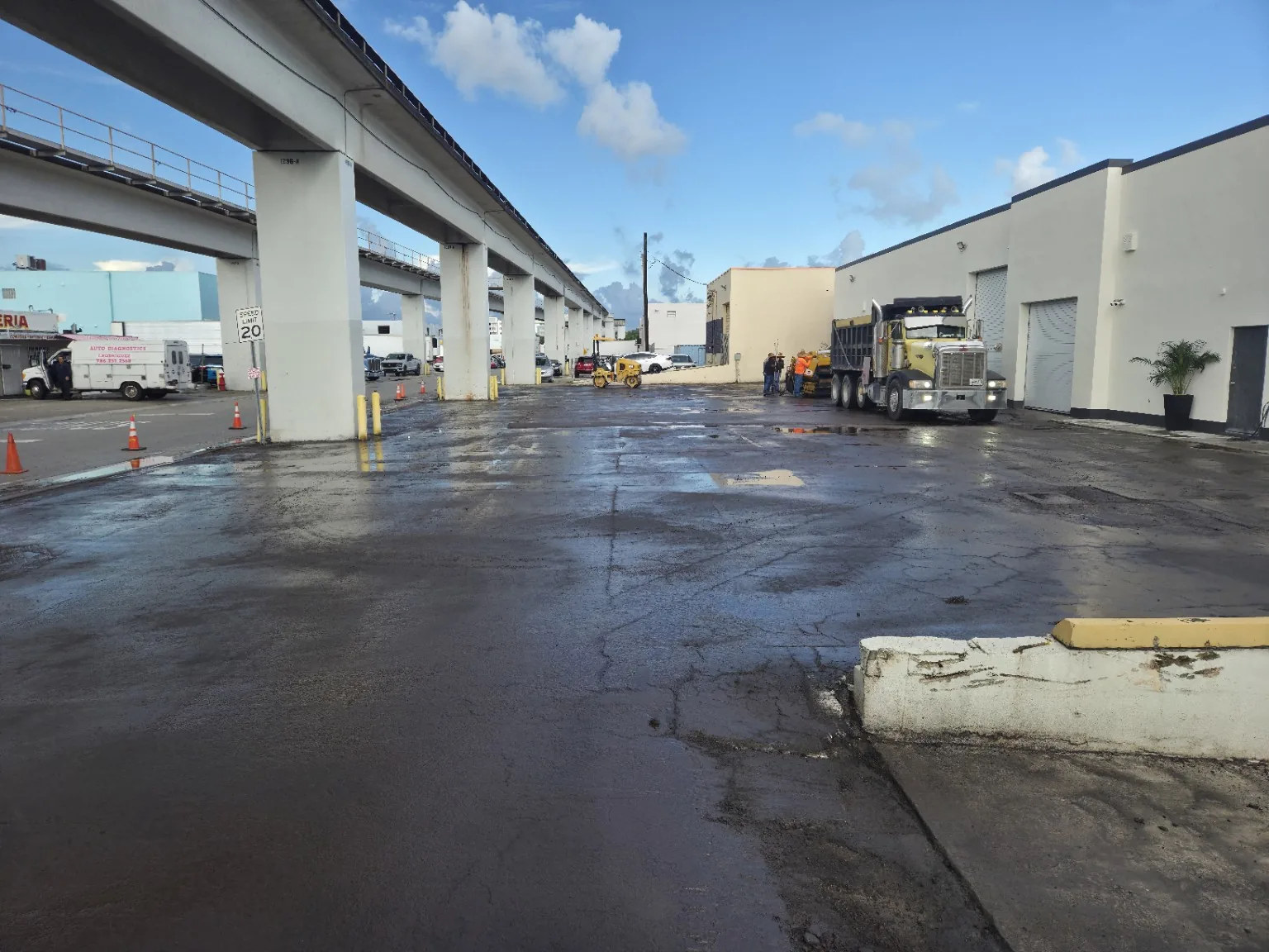 Commercial asphalt paving project area with paving crew and equipment